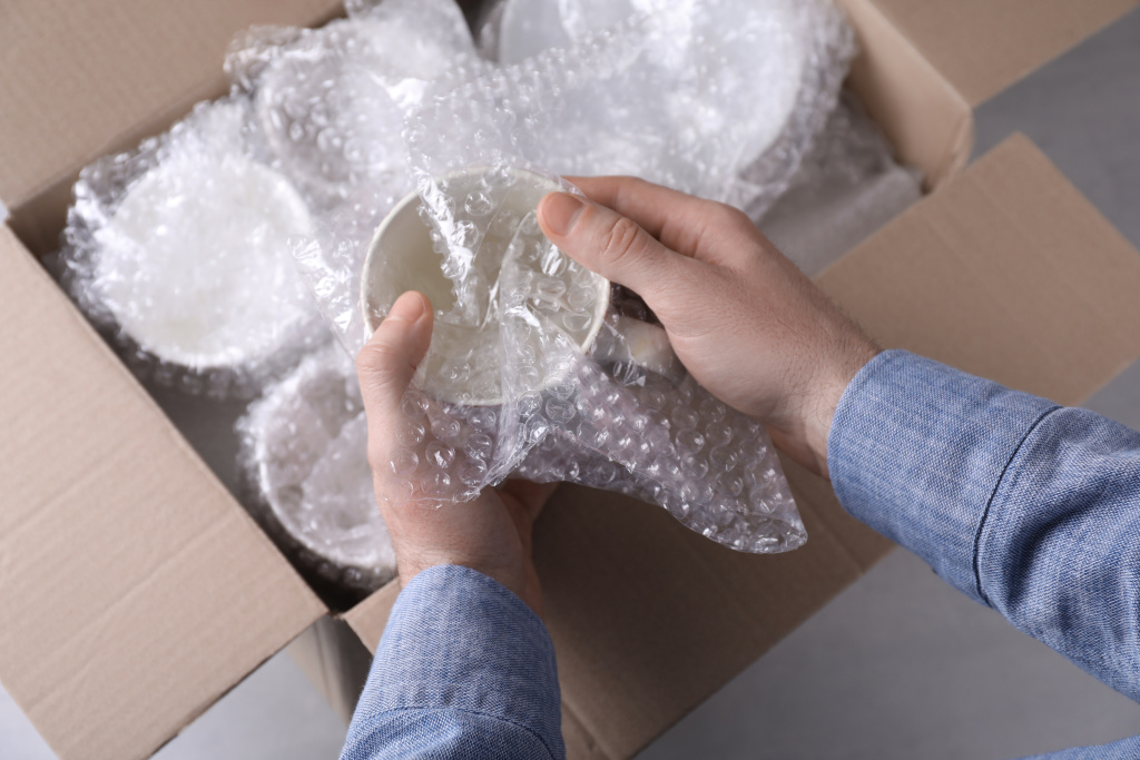 man-covering-ceramic-dishware-with-bubble-wrap-closeup.jpg man-covering-ceramic-dishware-with-bubble-wrap-closeup.jpg