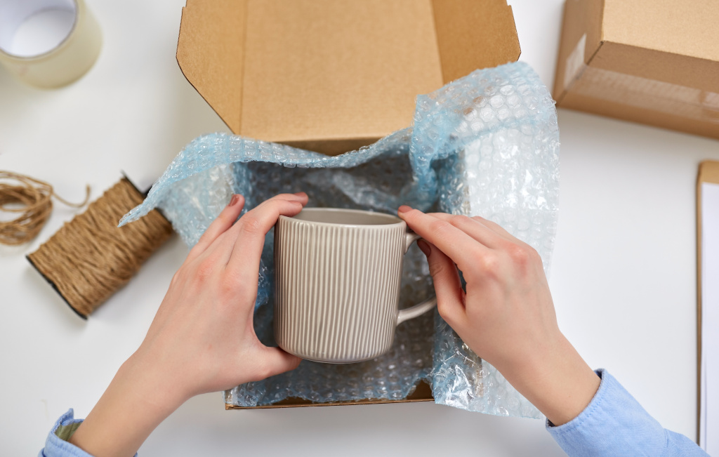 hands-packing-mug-parcel-box-post-office.jpg hands-packing-mug-parcel-box-post-office.jpg